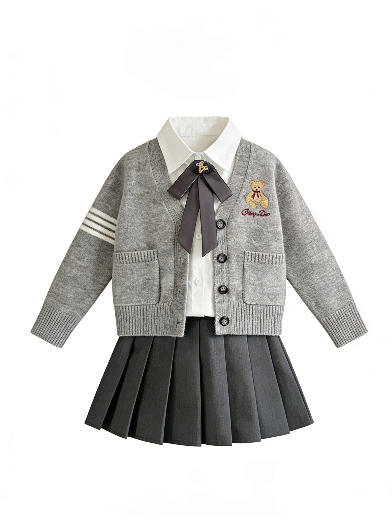 Grey knitted cardigan with teddy bear embroidery, white shirt, dark grey pleated skirt, and bow tie on a white background.